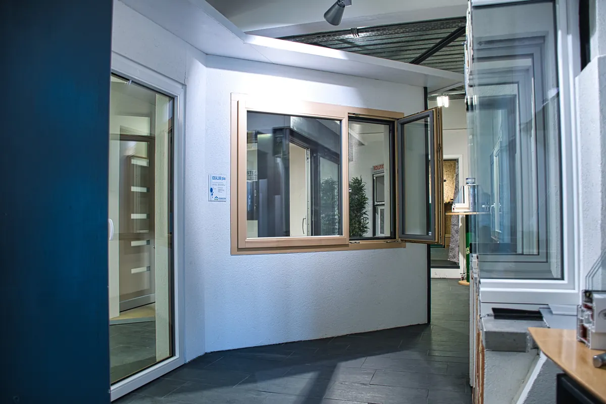 Ausstellungsraum mit geöffnetem Holzalufenster und Haustüren